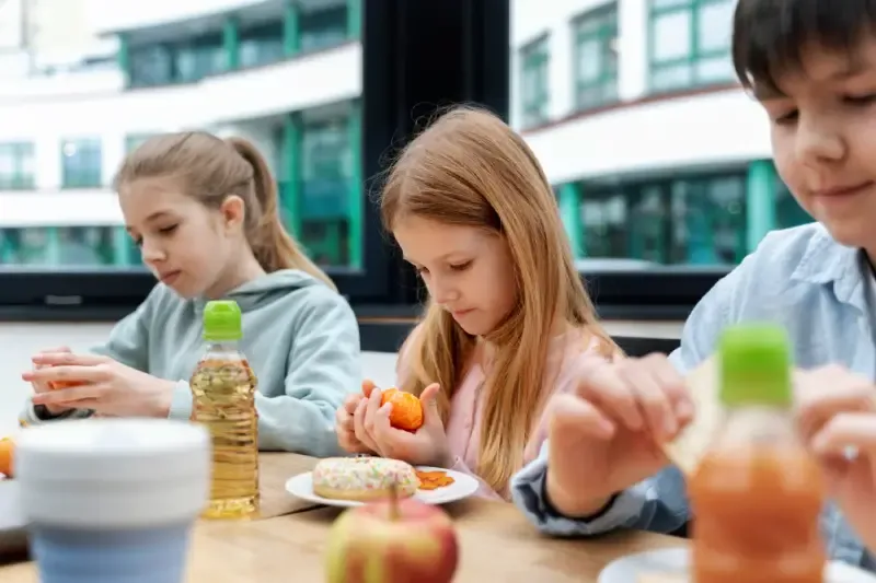 Das Titelbild zeigt Schüler beim gemeinsamen Mittagessen in der Schulkantine.
